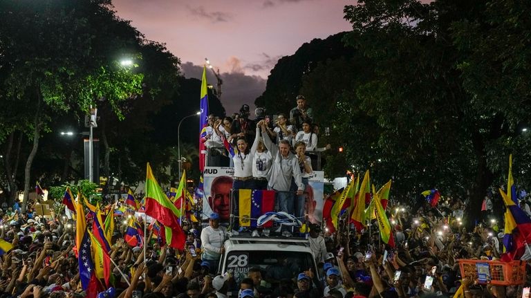 Opposition leader Maria Corina Machado, center left, and presidential candidate...