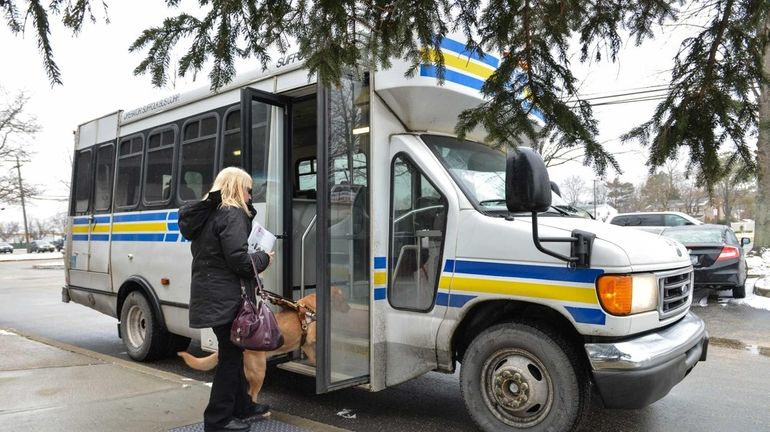 Marilyn Tucci, 61, of Shirley, boards a bus with her...