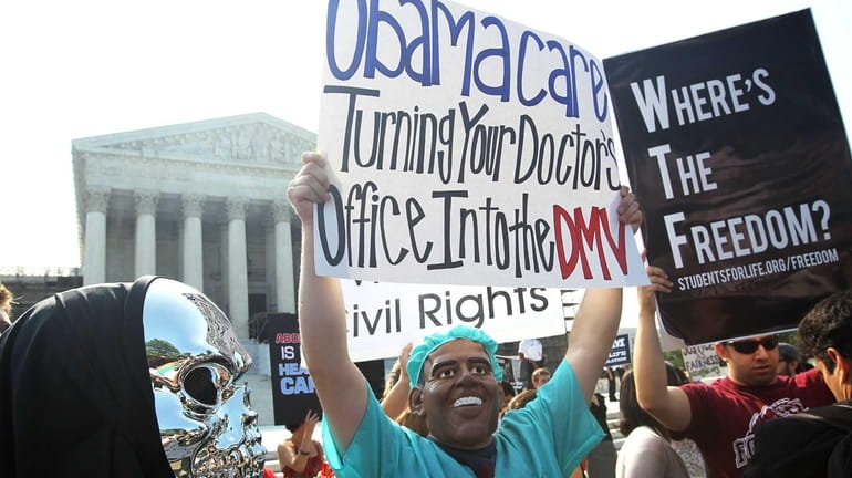 Anti-Obamacare protesters wear masks of U.S. President Barack Obama and...
