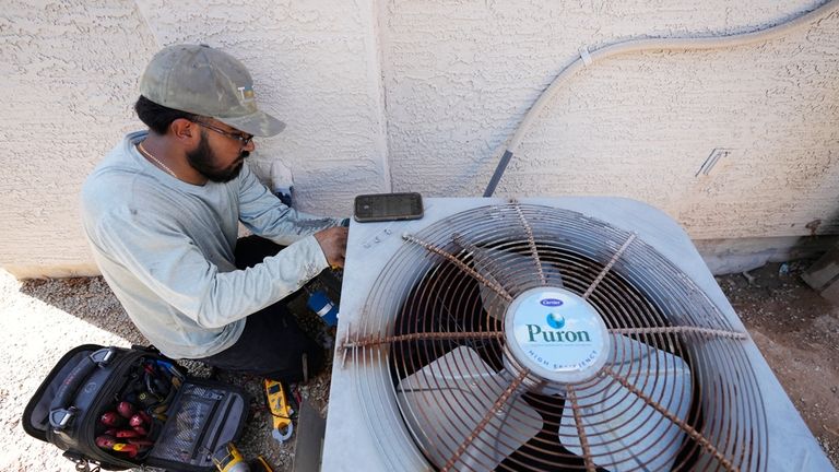 Total Refrigeration service tech Michael Villa works on replacing a...