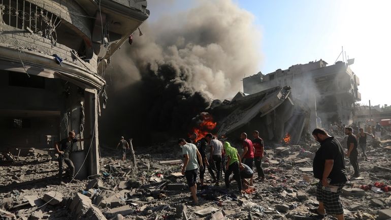 Palestinians inspect the damage of a house destroyed by an...