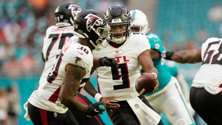 Atlanta Falcons quarterback Michael Penix Jr. (9) hands the ball...