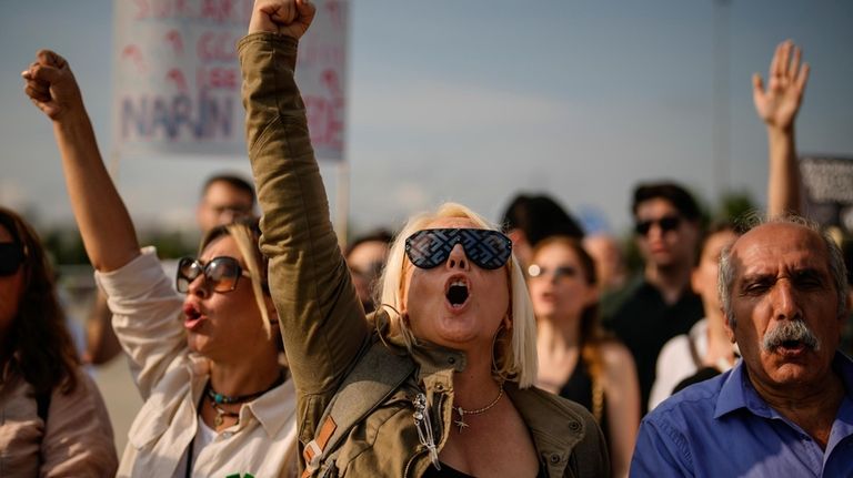 People shout slogans during a protest against a bill approved...