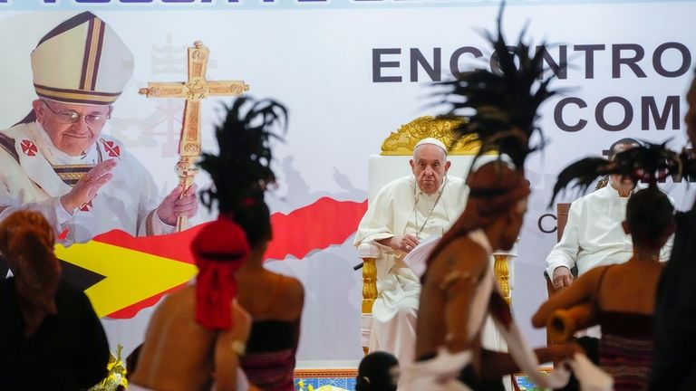 Pope Francis looks at traditional dancers as he arrives at...