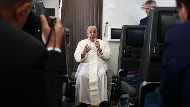 Pope Francis holds a news conference aboard the papal plane...