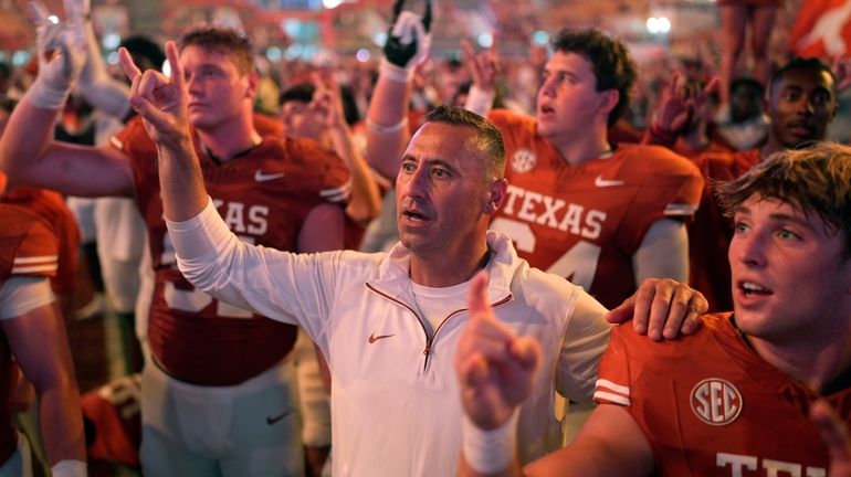 Texas head coach Steve Sarkisian, center, stands with players for...