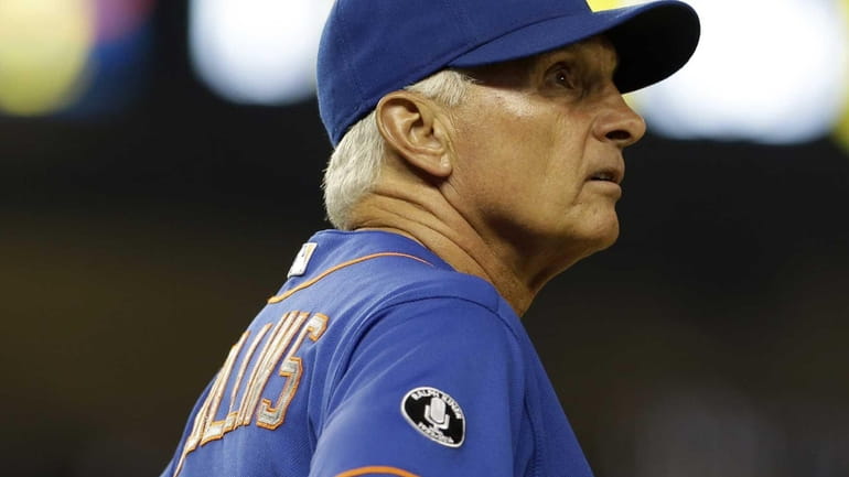 On the giant screen, Mets manager Terry Collins watches a...