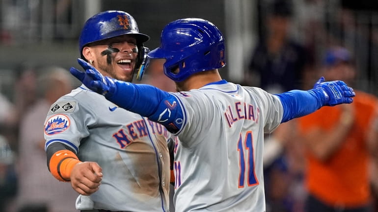 Mets' Francisco Alvarez, left, celebrates with teammate Jose Iglesias, right,...