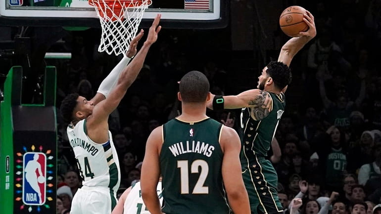 Celtics forward Jayson Tatum drives in for the slam dunk over...