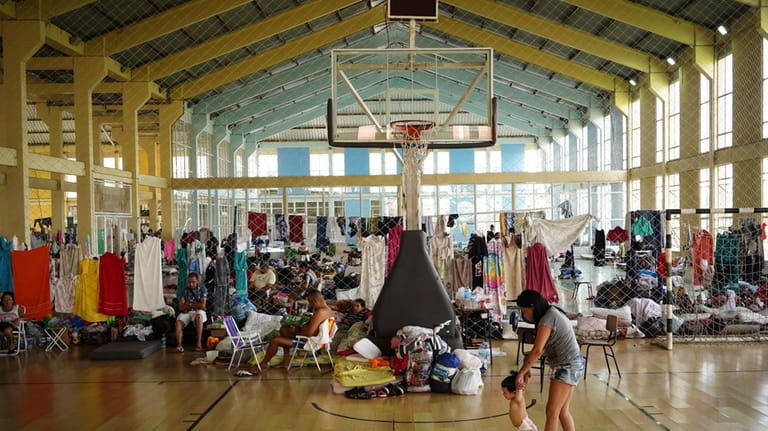 Residents rest in a gymnasium converted into a makeshift shelter...