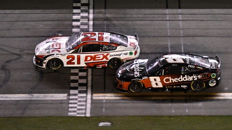 Harrison Burton (21) crosses the finish line ahead of Kyle...