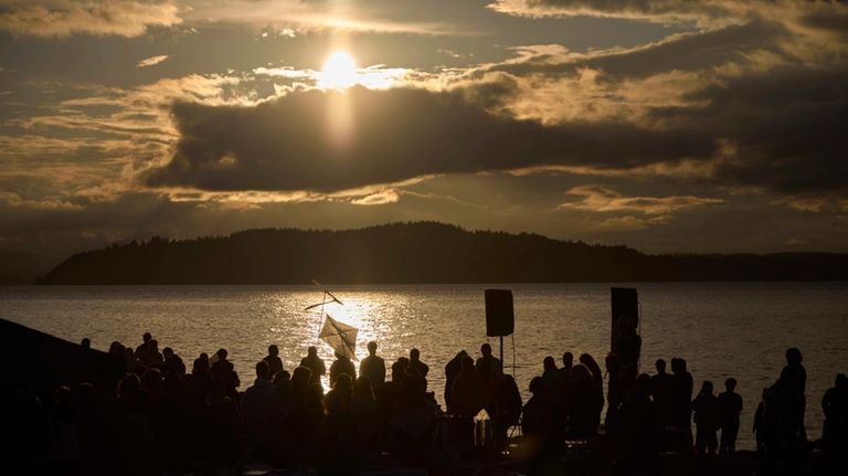 Attendees gather for a vigil on Alki Beach for the...