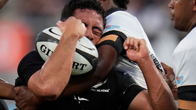 New Zealand's Anton Lienert-Brown holds on to the ball as...