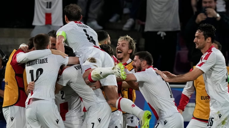 Georgia's players celebrate after forcing an own goal by Spain's...