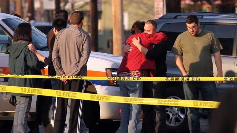 People console one and other at the scene of a...