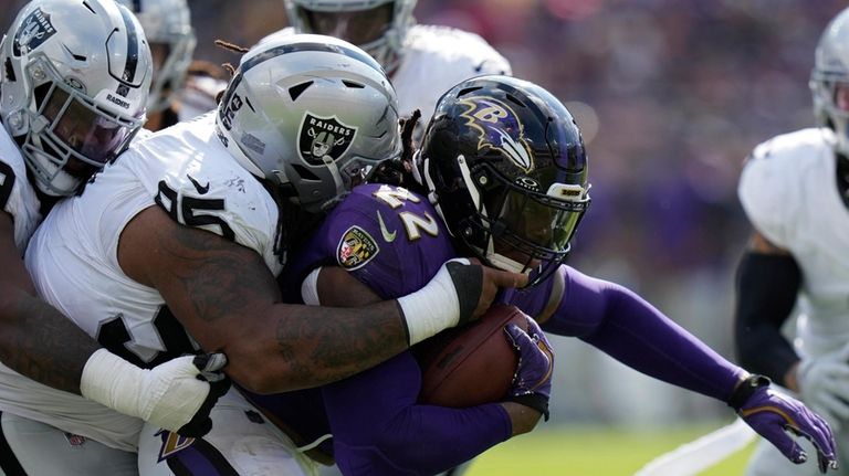 Las Vegas Raiders defensive tackle John Jenkins (95) tackles Baltimore...