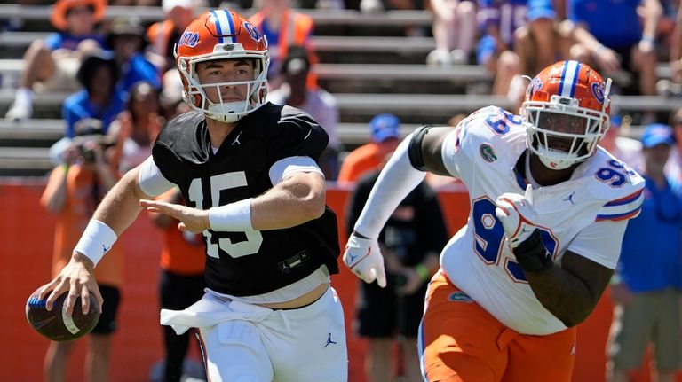 Florida quarterback Graham Mertz, left, looks for a receiver as...