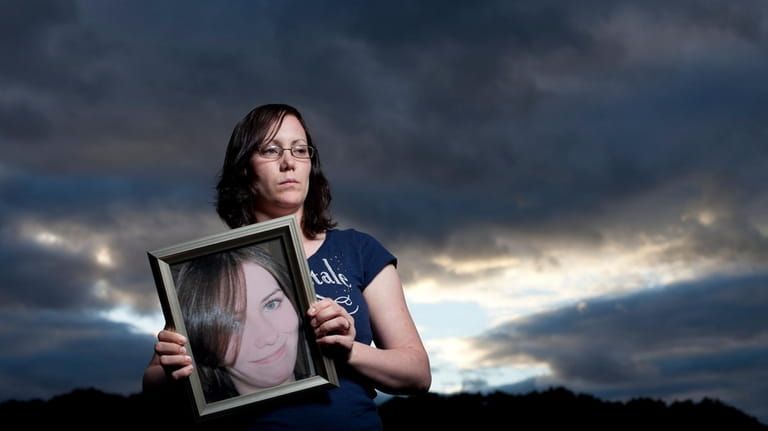 Melissa Cann holds a photo of her sister, Maureen Brainard-Barnes, whose body...