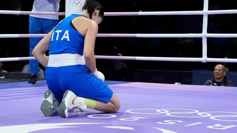 Italy's Angela Carini reacts after she was defeating by Algeria's...