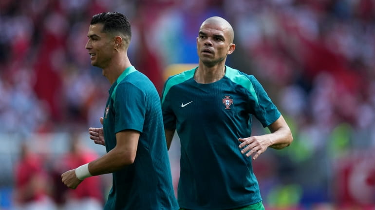 Portugal's Cristiano Ronaldo, left, and Portugal's Pepe warm up prior...