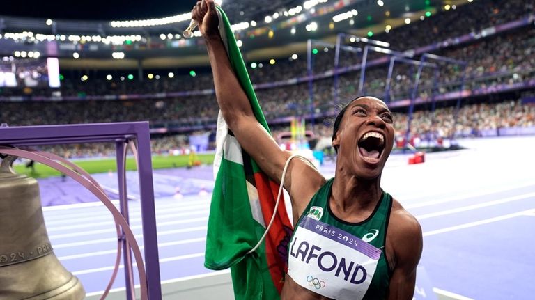 Thea Lafond, of Dominica, celebrates after winning the women's triple...