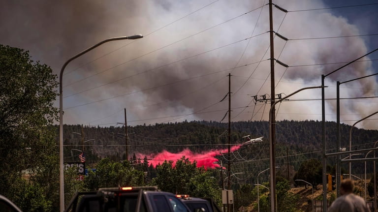An air tanker drops fire retardant called slurry over and...