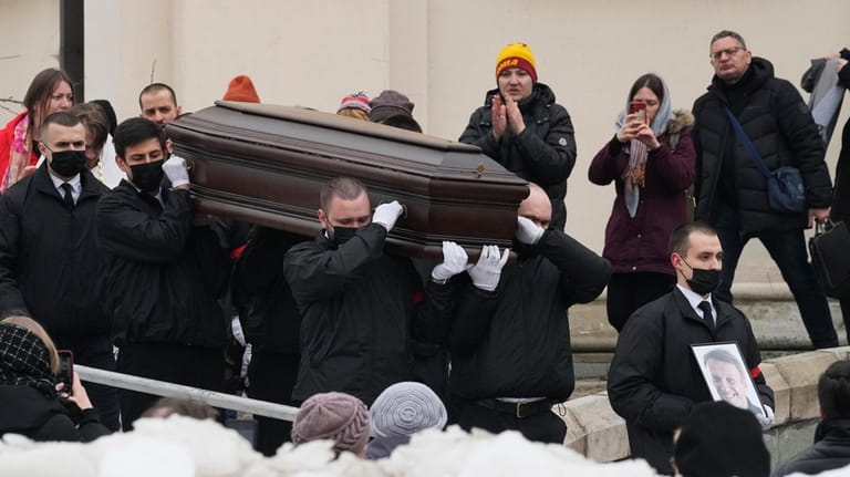 Workers carry the coffin and a portrait of Russian opposition...