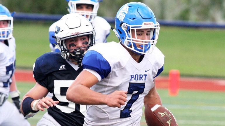 Port Washington quarterback Elliot Avidane looks for some running room while...