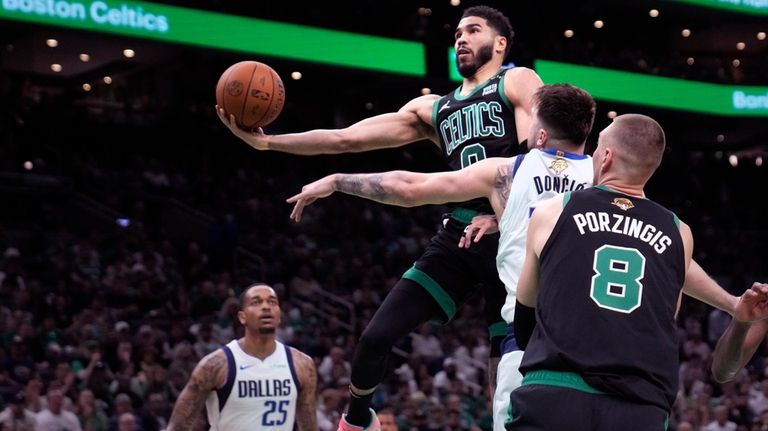 Boston Celtics forward Jayson Tatum (0) drives to the basket...