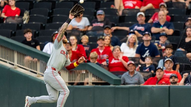 Cincinnati Reds outfielder Jake Fraley catches a pop fly hit...