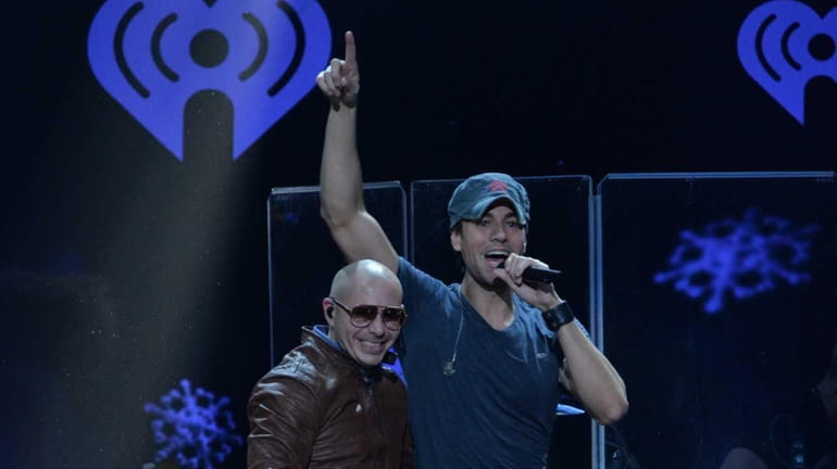 Pitbull, left, and Enrique Iglesias perform during Z100's Jingle Ball...