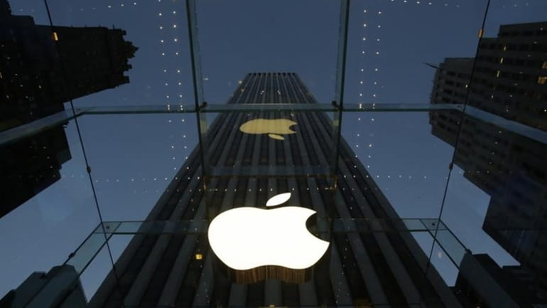 The Apple logo is illuminated in the entrance to the...