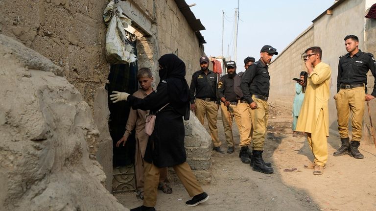 Pakistani police officers conducts biometric identification of a residents during...