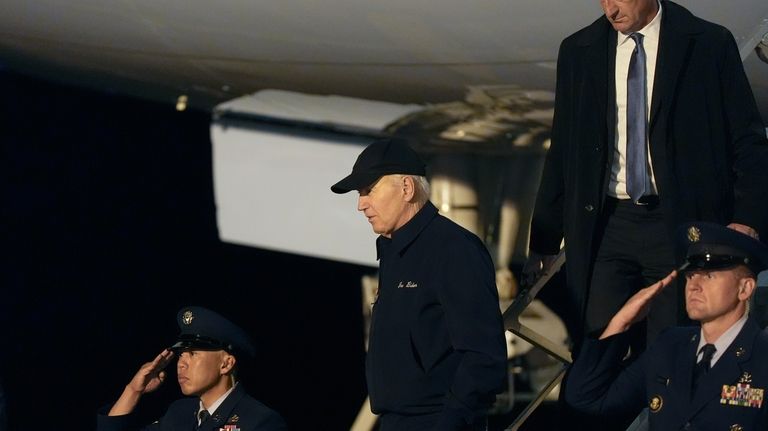 President Joe Biden walks down the steps of Air Force...