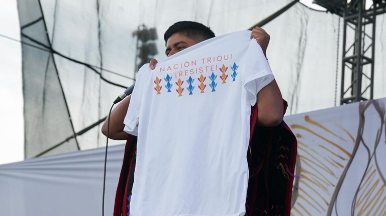 Mexican-Triqui artist Carlos CGH, wearing a black and red “gabán,”...