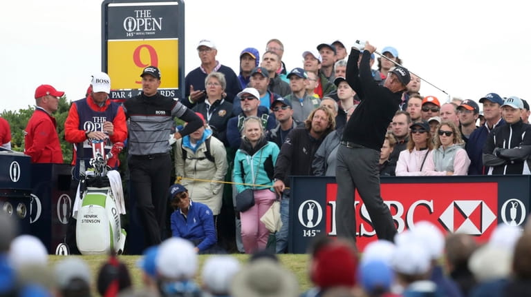 Phil Mickelson, of the United States, watched by Henrik Stenson,...