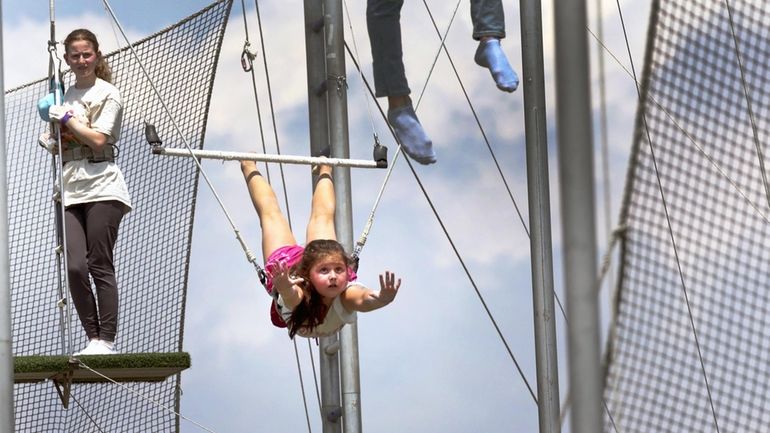 Annabelle Chmura, 6, of Ronkonkoma, goes airborne on the trapeze Saturday...