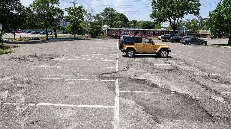 The rough surface of the south parking lot at the Long...