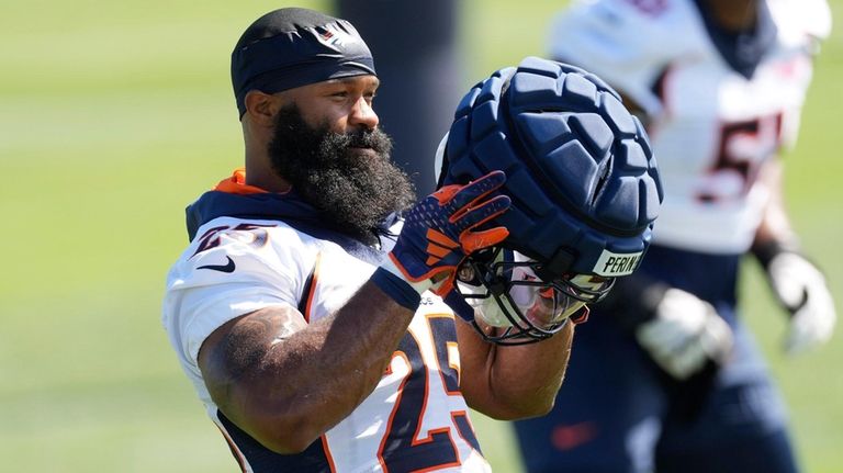 Broncos running back Samaje Perine puts on his helmet as...