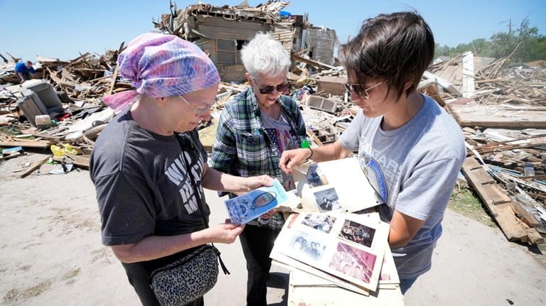Edith Schaecher, center, looks at a photo album recovered from...