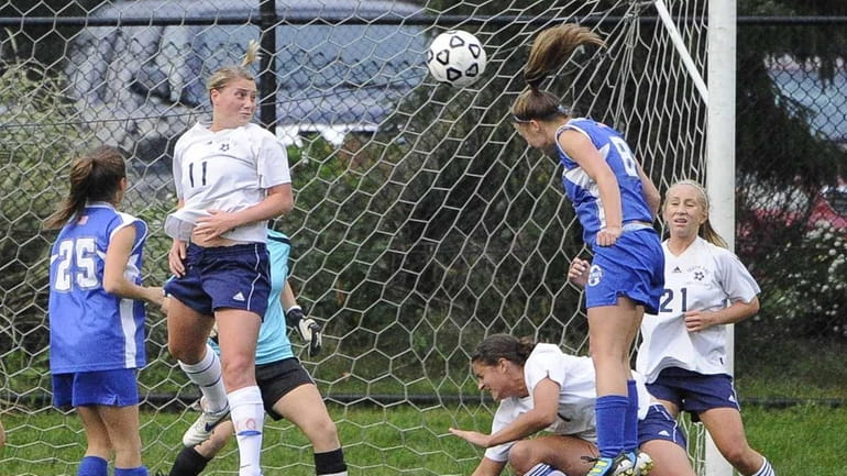Division's Alexa Schneider heads the ball into the net to...
