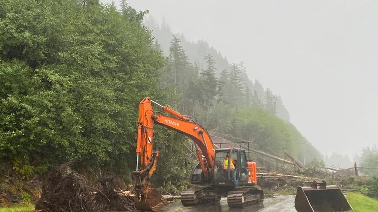 A worker clears debris after a deadly landslide in Ketchikan,...