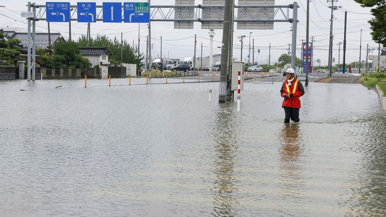 A road is flooded after a heavy rain in Sakata,...