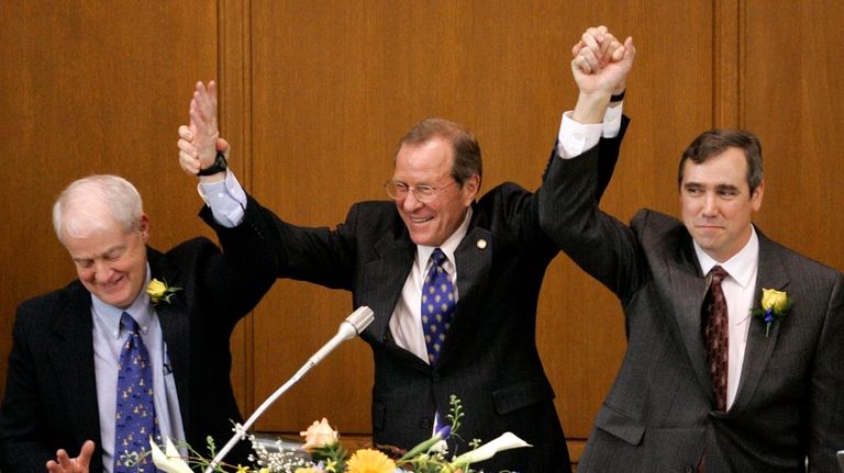 Oregon Gov. Ted Kulongoski, center, holds raised hands with Senate...