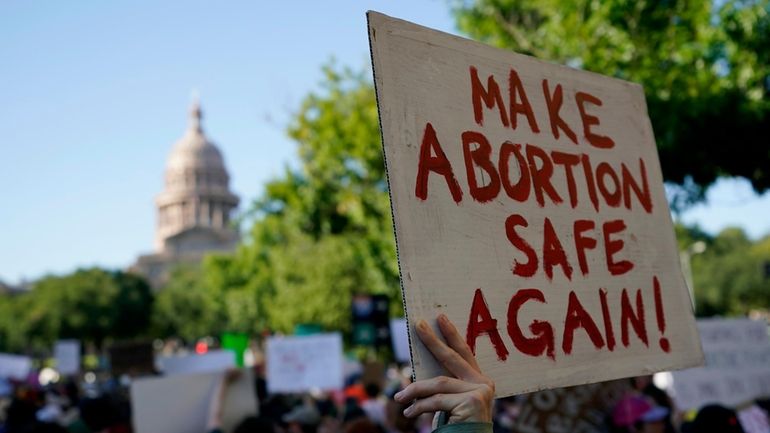 Demonstrators march and gather near the state capitol following the...