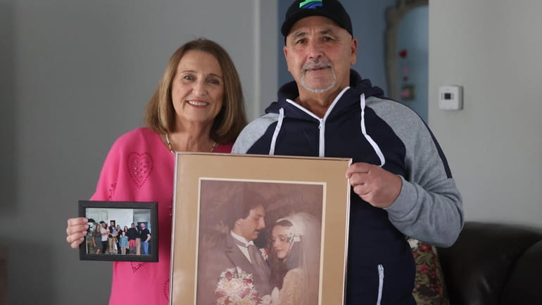Denise and Bill Ferraro hold their wedding picture at their Coram...