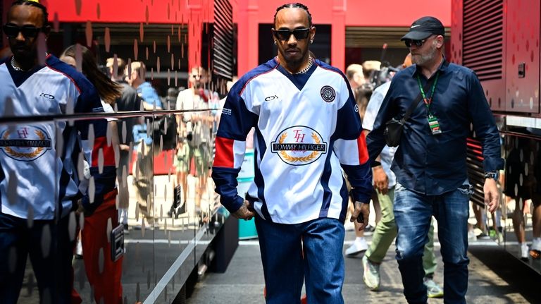 Mercedes driver Lewis Hamilton of Britain walks through the paddock...