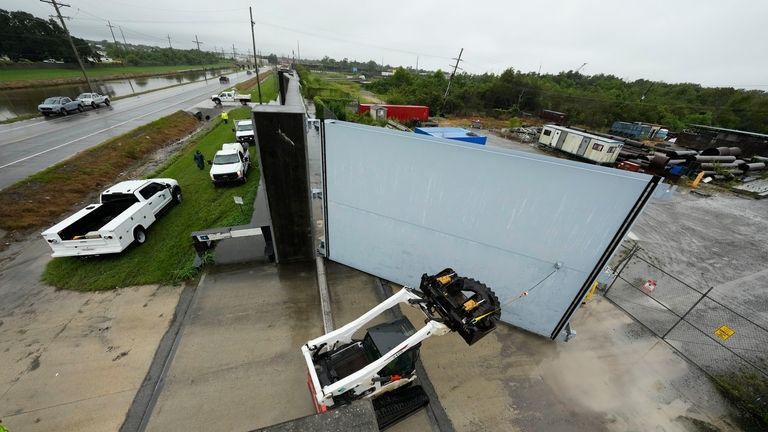 Workers from the Southeast Louisiana Flood Protection Authority-West close floodgates...