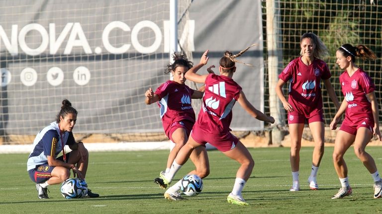 Spain's women's national team coach Montse Tome, left, watches players...