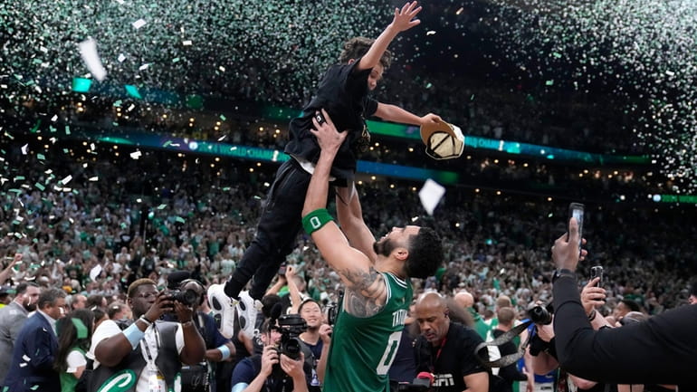 Boston Celtics forward Jayson Tatum (0) lifts his son Deuce...